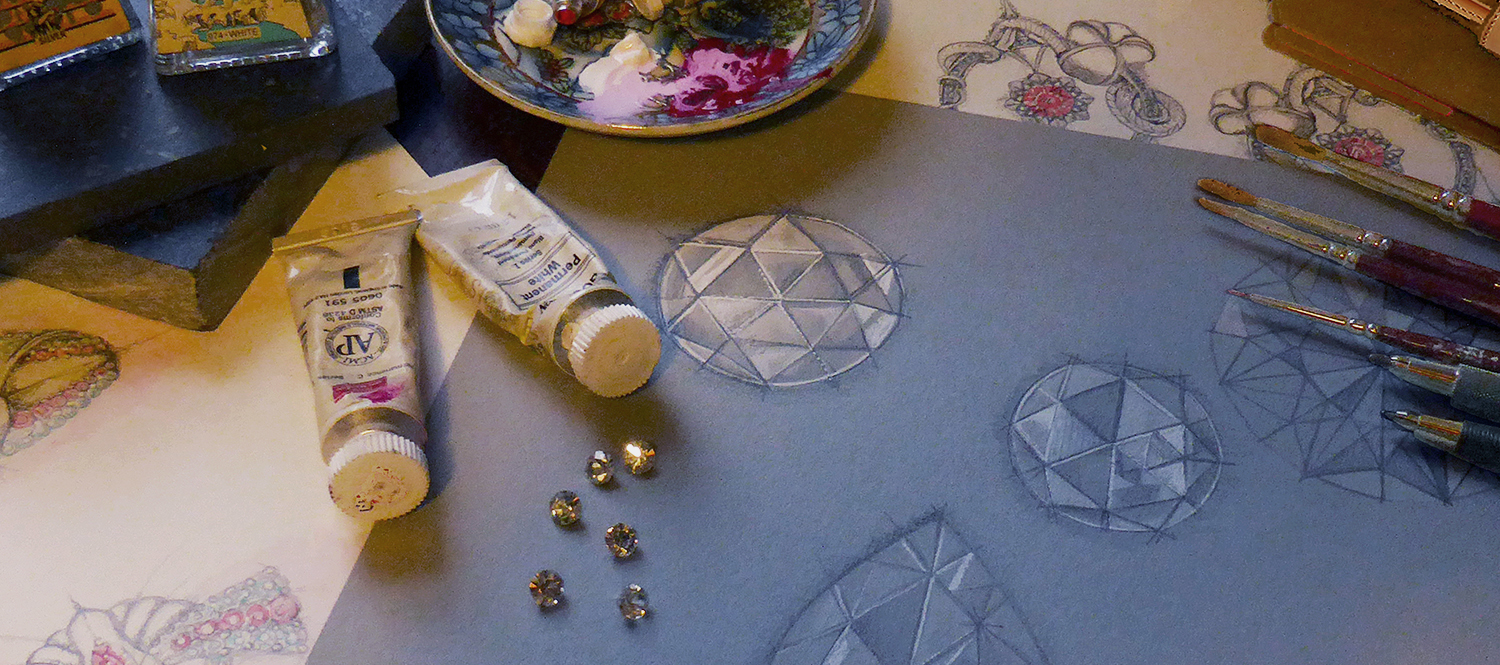 Hand-drawn jewellery design sketches, gemstones and tools for a bespoke wedding ring commission